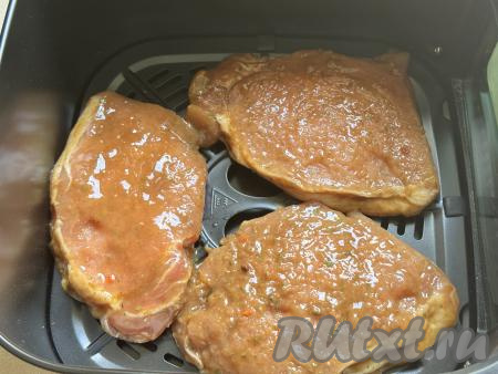 Замаринованные отбивные из свинины выложить на решётку аэрогриля. У меня вместились 3 штуки. Оставшиеся отбивные я готовила во второй заход. Установить чашу со свиными отбивными в аэрогриль и готовить при температуре 200 градусов 10 минут.