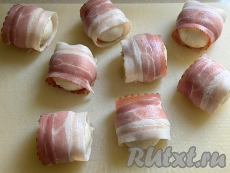 Бекон я купила уже нарезанный на тонкие полоски. Если вы купили бекон одним куском, тогда его нужно будет нарезать на тонкие, длинные полосы. Каждую шляпку шампиньона, фаршированную сыром, обернуть в полоску бекона.