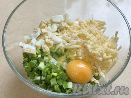 Сыр натереть на крупной тёрке. В глубокой миске соединить нарезанные зелёный лук и варёные яйца, добавить творог, натёртый сыр, вбить сырое яйцо, посолить по вкусу.