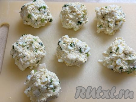 Перемешать получившееся тесто для ленивых пирожков столовой ложкой до однородности. Тесто должно быть комковатым, из него достаточно просто формировать округлые заготовки ленивых пирожков. Руками, смоченными водой, разделить тесто на 7 равных частей.