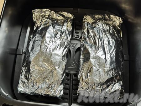 Завернуть каждое куриное филе в отдельный лист фольги, плотно скрепляя края фольги со всех сторон, затем выложить на решётку чаши аэрогриля.