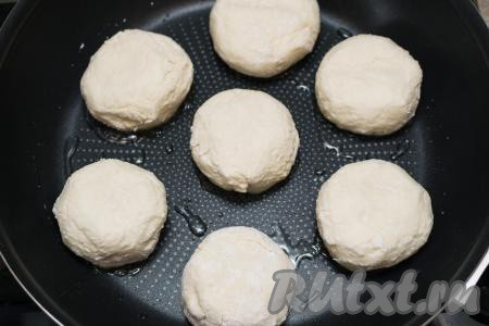 В сковороду влить растительное масло, хорошо разогреть, после этого выложить сырники из творога и кефира. Жарить на среднем огне до подрумянивания снизу (ориентировочно в течение 2-3 минут).