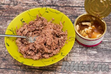 Пока варятся картошка с морковью, нужно открыть банку с тушёнкой. Переложить мясо без жира на тарелку. Размять тушёнку вилкой до однородности.