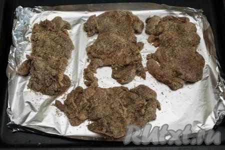Подготовленные отбивные из филе бёдер курицы выложить на противень, заранее застеленный фольгой (или пергаментом), отправить в духовку, разогретую до 180 градусов.