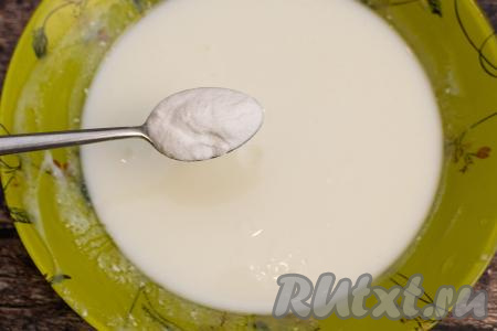 Пока яйца взбиваются с сахаром, нужно в глубокую тарелку влить тёплый кефир, всыпать соду, тщательно перемешать ложкой и оставить на 3-5 минут. Для того чтобы кефир стал тёплым, я подогреваю его в микроволновке. Для этого наливаю кефир в глубокую тарелку, ставлю в микроволновку, прогреваю на максимальной мощности в течение 30 секунд, после этого хорошо перемешиваю и ещё раз отправляю в микроволновку на 30 секунд. Микроволновка греет неравномерно, поэтому, если кефир не перемешивать после того как он подогреется в течение 30 секунд, он может свернуться. Ну а затем в тёплый кефир добавляю соду.