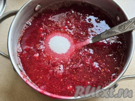 Непроцеженную ягодную массу, оставшуюся в глубокой миске, переложить в кастрюлю с толстым дном, сюда же добавить жмых, оставшийся в сите, всыпать сахар, влить 300 миллилитров воды, перемешать.&nbsp;