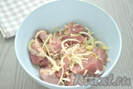 Хорошо перемешиваем кусочки свинины с луком и чесноком.