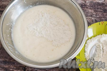 В отдельную тарелку отмерить 100 грамм муку. В миску с йогуртовой массой, покрывшейся пузырьками, всыпать 50 грамм отмеренной муки, перемешать лопаткой (или столовой ложкой) до однородности. Затем начать добавлять по 1 столовой ложке оставшейся муки, сразу вмешивая её в тесто для панкейков.