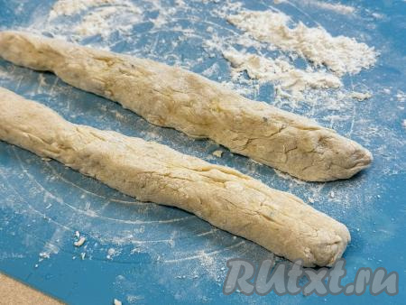 На припылённой мукой поверхности разделить картофельное тесто на две части. Из каждой части теста руками сформировать колбаску, прокатав тесто ладонями. В результате у нас получатся 2 картофельных колбаски.
