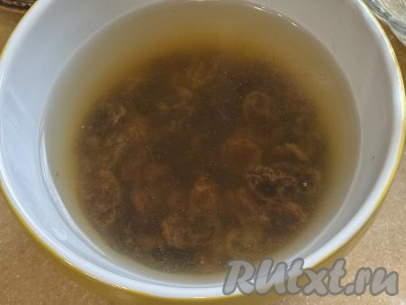 Изюм промыть проточной водой, выложить в глубокую мисочку, полностью залить кипящей водой, оставить минут на 5. Затем распарившийся изюм откинуть на сито, промыть его водой. Оставить в сите на 1-2 минуты, чтобы слилась лишняя вода. Разложить изюм на бумажном полотенце, чтобы он обсох. Сразу же осмотреть изюм, удалить остатки веточек, если они есть.