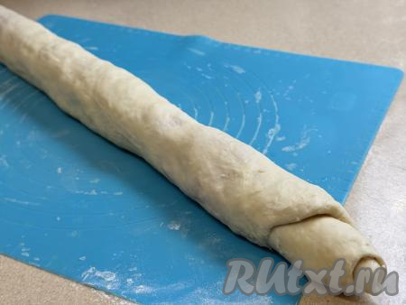 Начиная с более широкого края пласта, свернуть тесто с фаршем в плотный рулет.&nbsp;