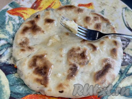 Готовый хычин с мясом переложить со сковороды на плоскую тарелку и сразу смазать горячую лепёшку кусочком сливочного масла с двух сторон. Поскольку хычин выпекается на сухой сковороде, благодаря смазыванию сливочным маслом, тесто лепёшки становится нежным, мягким.