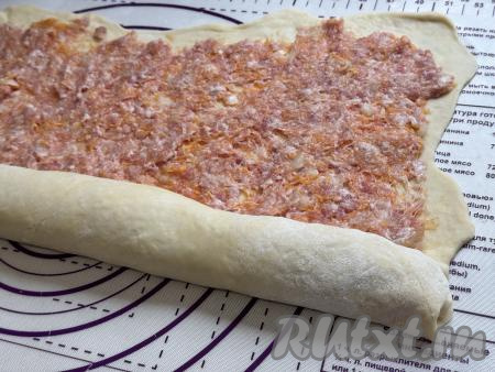 Начиная с более широкой стороны пласта теста, свернуть тесто с фаршем в плотный рулет.&nbsp;