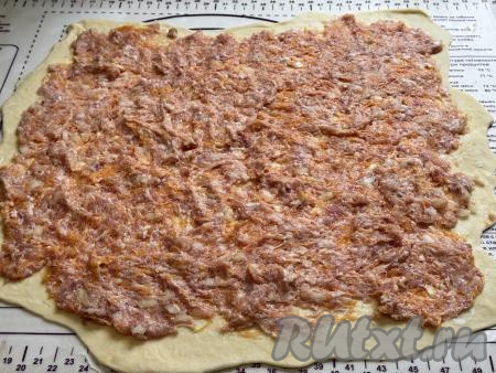 На раскатанное тесто выложить тыквенно-мясную начинку, равномерно её распределить, отступая от краёв теста по 1 сантиметру.&nbsp;