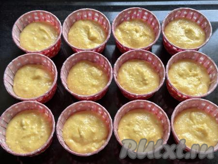 Тесто, замешанное из творога и кукурузной муки, разложить по формочкам для кексов, заполняя их немного больше, чем наполовину. Формочки с тестом поставить на противень. Я выпекала творожные кексы в бумажных формочкам, их, как и силиконовые формочки, перед выкладыванием теста можно маслом не смазывать. Железные формочки для кексов перед выкладыванием теста нужно смазать маслом. Тесто я разложила по 12 формочкам. 