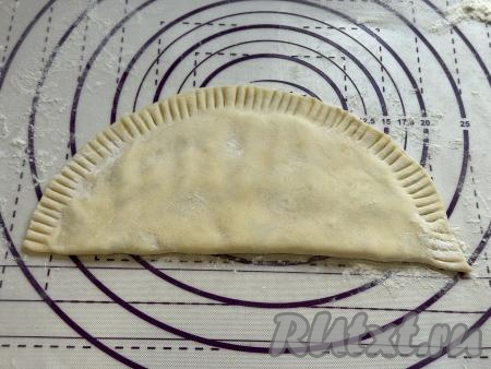 Сторону с начинкой накрыть чистой стороной круга, тщательно скрепить края получившегося чебурека. Я скрепила края чебурека вилкой. Для того чтобы вилка не липла сильно к тесту, зубцы вилки можно периодически обмакивать в муку.
