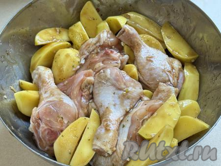 Тщательно перемешать части курицы и картошку, покрывая их маслом, соусом "Терияки", специями и чесноком со всех сторон, а затем оставить мариноваться при комнатной температуре минут на 30 (можно оставить мариноваться и на более длительное время, но тогда миску с мясом и картофелем нужно будет накрыть крышкой и отправить в холодильник).&nbsp;