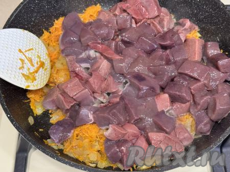 После того как морковка станет мягкой, в сковороду с овощами выложить свиную печень, нарезанную на средние кусочки.&nbsp;