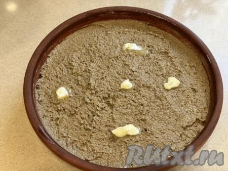 У нас остались грамм 15 размягчившегося масла. Частью этого масла нужно смазать жаропрочную форму (я взяла керамическую форму диаметром 20 сантиметров). Выложить получившийся печёночный паштет в подготовленную форму для запекания. Оставшиеся кусочки масла разложить поверх паштета.&nbsp;Запекать паштет из свиной печени и сливок в разогретой до 180 градусов духовке 20 минут.