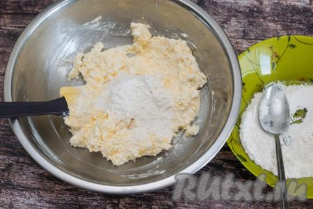 Отмерить в отдельную тарелку муку. В миску с творожно-сырной массой начать небольшими порциями подсыпать отмеренную муку, каждый раз тщательно вмешивая её лопаткой.