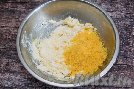 Сыр натереть на мелкой тёрке и добавить его в миску с творожной массой.