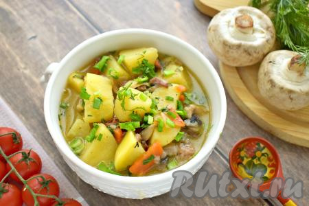 Тушёную картошку с грибами и тушёнкой раскладываем по тарелкам и в горячем виде подаём к столу, дополнив, по желанию, консервированными или свежими овощами.