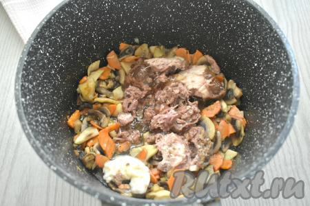 К шампиньонам, обжаренным с овощами, добавляем тушёнку (у меня - тушёнка из говядины). Я добавила тушёнку вместе с жиром, но при желании можете жир убрать. Обжариваем тушёнку с грибами и овощами 5 минут, достаточно часто перемешивая и равномерно распределяя кусочки мяса.&nbsp;