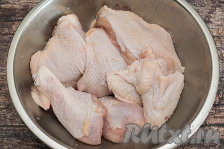 Части курицы промыть водой, обсушить, выложить в миску, посолить по вкусу. Если будете в дальнейшем добавлять специи, тогда, всыпая соль, учитывайте, есть ли соль в составе специй.