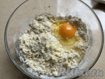 В миску с песочной крошкой добавить сырое яйцо.&nbsp;