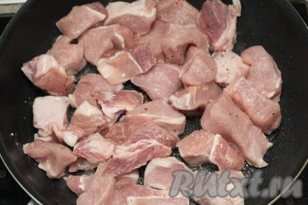 На сковороду влить растительное масло, хорошо разогреть, выложить кусочки свинины и обжарить на достаточно сильном огне, периодически перемешивая.