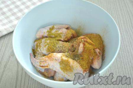 Куриные крылышки перекладываем в миску, по вкусу их солим, посыпаем специями.