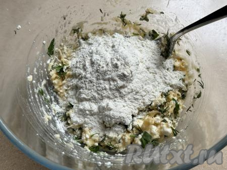 Начать частями добавлять муку в получившуюся массу из творога, сыра и зелени, каждый раз тщательно перемешивая.