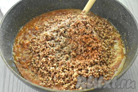 Затем в сковороду с тушёнкой, протушившейся с томатной пастой и овощами, выкладываем подготовленную гречку. По вкусу солим и перчим, обязательно учитывая, что тушёнка уже солёная и содержит специи.