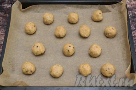 Отщипывая от теста руками небольшие части теста (каждая часть теста у меня весила примерно 50 грамм), скатывать их в шарики и на небольшом расстоянии друг от друга выкладывать на противень, застеленный пергаментом. В результате у меня получились 14 шариков. Если в процессе лепки шариков тесто будет сильно липнуть к рукам, можно периодически смачивать ладони водой.