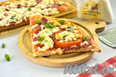 Готовую выпечку достаём из духовки. Очень вкусной, аппетитной пицце даём остыть в течение пары минут, чтобы адыгейский сыр «схватился», а затем нарезаем на кусочки и в горячем виде подаём к столу. Для того чтобы выпечка стала ещё более ароматной, перед подачей её можно посыпать свежим базиликом, зелёным луком или другой зеленью.