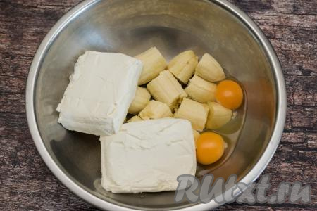 В миску с бананами добавить творог и сырые яйца.