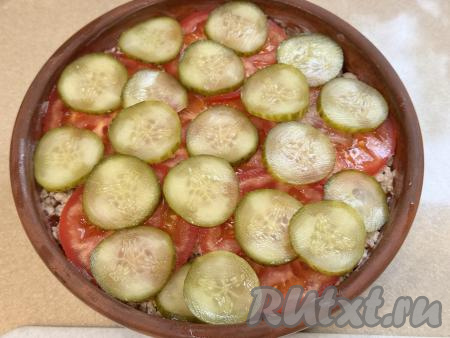Затем выложить маринованный огурчик, нарезанный на тонкие кружочки.