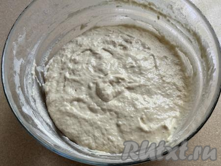Частями добавляя оставшуюся муку и каждый раз очень хорошо вмешивая её ложкой, замесить однородное, вязкое, в меру густое дрожжевое тесто, как на фото. Как только добились такой густоты теста для оладий, значит больше муку не нужно добавлять. Ориентируйтесь именно на густоту теста, а не на количество муки, указанное в ингредиентах, ведь жирность сметаны, качество муки, величина яйца могут быть разными. Миску с дрожжевым тестом, замешанным на сметане, затянуть пищевой плёнкой (или прикрыть полотенцем) и поставить в тёплое место минут на 35.&nbsp;