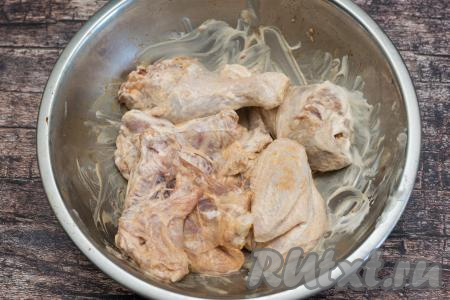 Перемешать части курицы, покрывая их сметаной со всех сторон. Оставить мясо на 30 минут, чтобы кусочки курицы немного промариновались (можно оставить и на более длительное время, но тогда миску с курицей, накрыв крышкой, нужно поставить в холодильник).