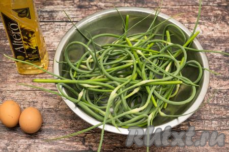 Подготовить продукты для приготовления чесночных стрелок, жареных с яйцом на сковороде. Стрелки чеснока лучше собирать вовремя, пока они ещё молодые, то есть мягкие, сочные, ярко-зелёного цвета.