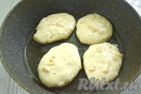 Разогреваем на сковороде растительное масло. Выкладываем на разогретую сковороде по 1 столовой ложке теста с абрикосами, формируя округлые оладьи.