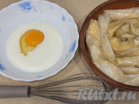 Для получения заливки в отдельной миске соединить молоко, щепотку соли и 1 сырое яйцо, перемешать венчиком до однородности.