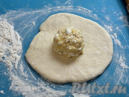 На присыпанной мукой поверхности каждую часть теста раскатать в лепёшку диаметром примерно 15 сантиметров. В середину каждой лепёшки выложить одну часть творожно-сырной начинки.&nbsp;