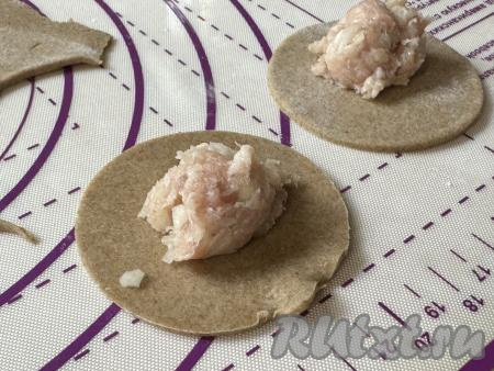 В центр каждого кружка из теста выложить ложку мясного фарша.
