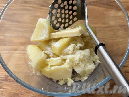 К слегка остывшей картошке добавить сливочное масло, растолочь толкушкой в пюре до однородности.