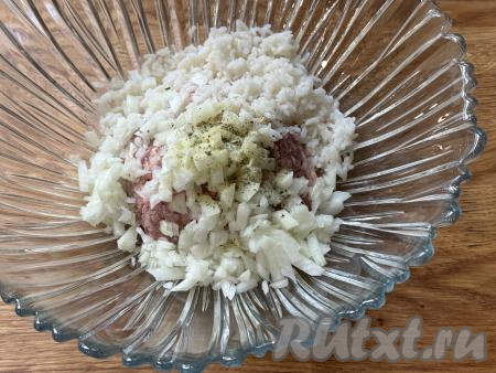 Капустные листья для формирования голубцов должны быть достаточно эластичными, для этого их можно размягчить в микроволновке или в кастрюле. Я предпочитаю размягчать листья в микроволновке, для этого нужно обернуть кочан в пищевую плёнку, поместить в микроволновку на максимальную мощность на 10-15 минут (до размягчения листьев), затем развернуть капусту, отделить нужное количество размягчившихся листьев. Можно размягчить листья капусты и, поместив кочан в кастрюлю с кипящей водой, проварить 4-5 минут, снять размягчившиеся верхние листья, снова поместить в кастрюлю и варить ещё 4-5 минут, отделяя мягкие листья. Для формирования голубцов я использовала 7 листьев. Пока размягчаются капустные листья, можно заняться начинкой, для этого в миску нужно выложить фарш, добавить мелко нарезанный (или пропущенный через мясорубку) лук, остывший рис, посолить, приправить любимыми специями (я использую пряную соль).&nbsp;