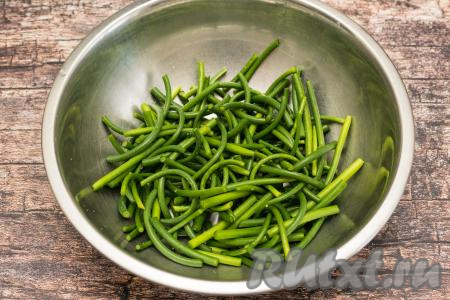Сложить подготовленные стрелки в миску и посолить их по вкусу.