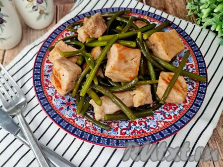 Нежные, мягкие кусочки свинины вместе с аппетитными, очень вкусными стрелками чеснока разложить по тарелкам и, дополнив гарниром (например, булгуром, рисом, отварным картофелем), в горячем виде подать к столу.