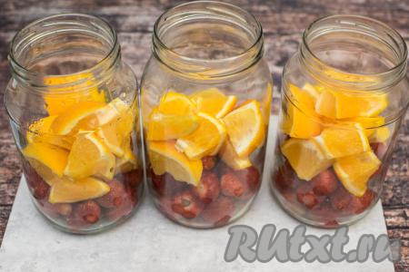 Разложить кусочки апельсинов в банки поверх клубники.