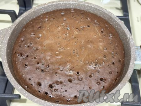 Поставить сковороду на медленный огонь, закрыть крышкой. Выпекать минут 15 (поверхность шоколадного пирога должна стать практически сухой).&nbsp;